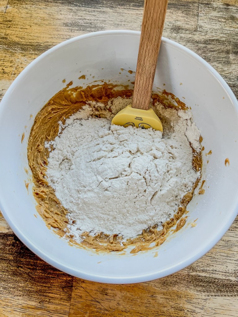 A large mixing bowl with peanut butter cookie batter inside