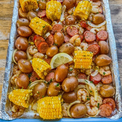 Shrimp Boil Sheet Pan fresh out of the oven with lemon juice, zest, and parsley for garnish