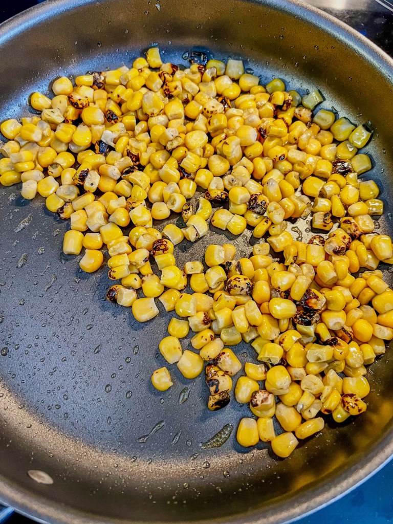 Roasted corn cooking in a skillet