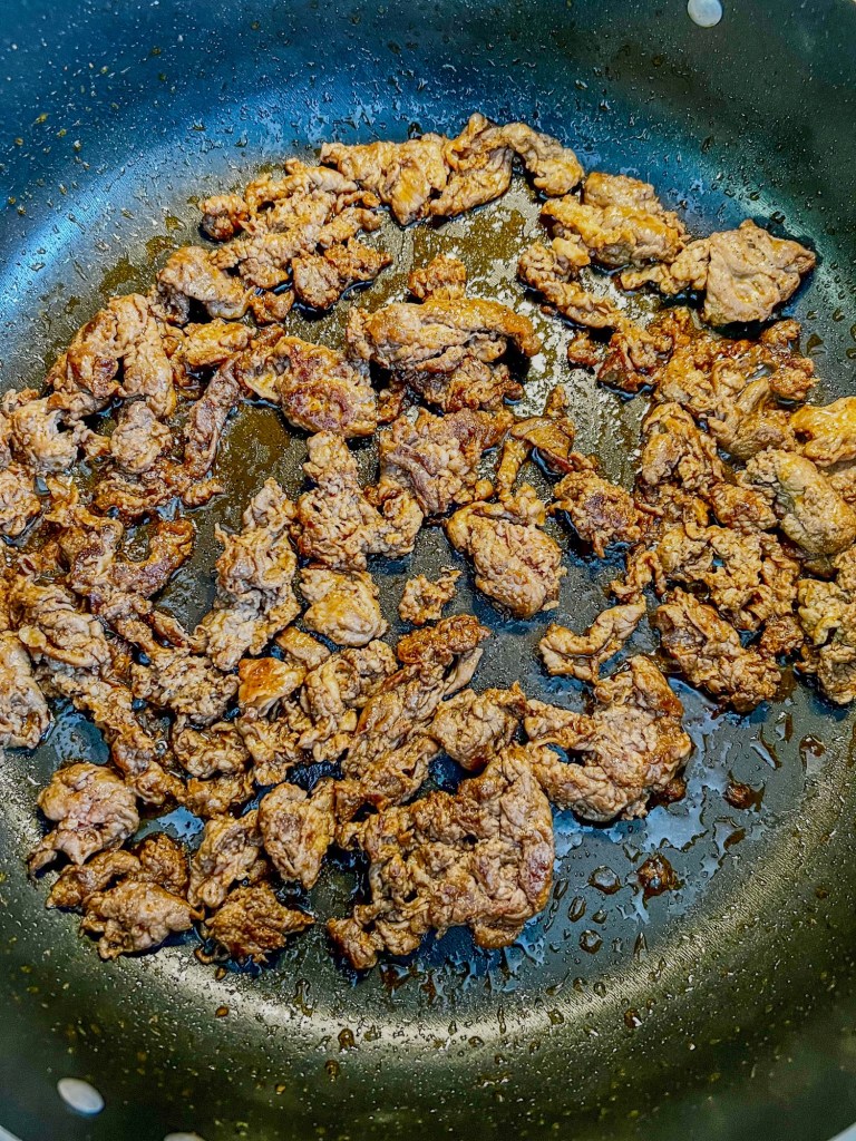 Shaved beef steak that's been seared in a skillet for southwest salad