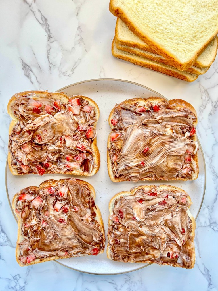 Bread being stuffed with a Nutella strawberry filling to make French toast