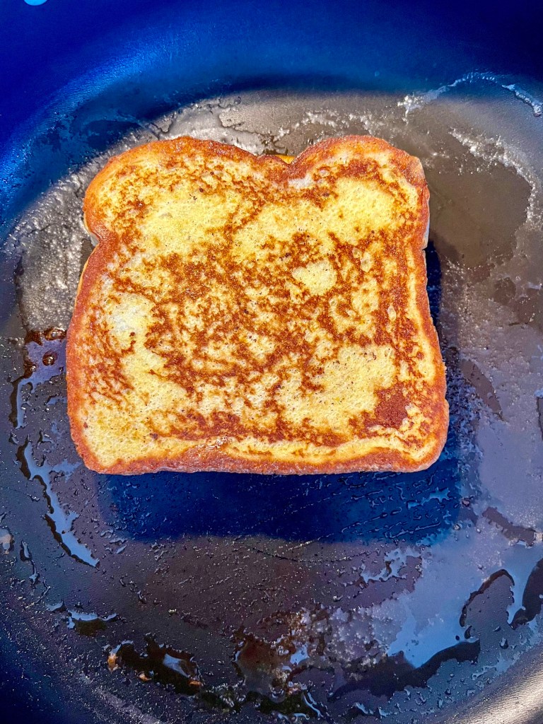 Stuffed French toast cooking in a skillet on the stove