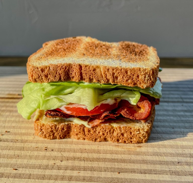 Ultimate BLT Sandwich on a wooden cutting board