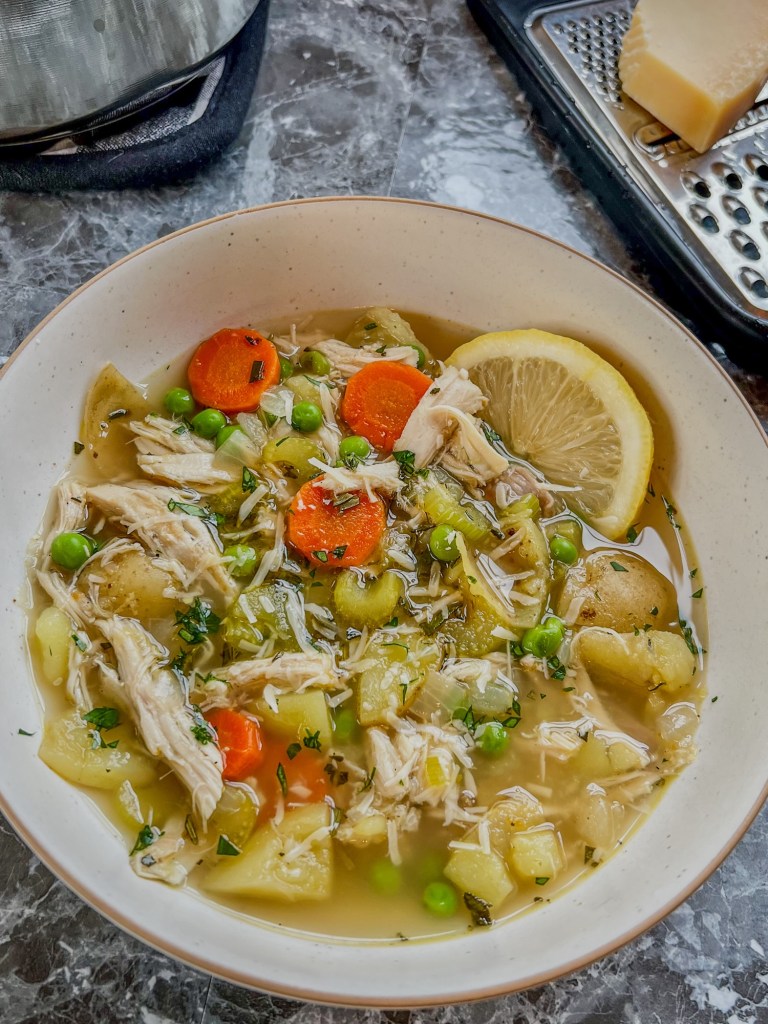 A white bowl filled with turkey stew with a lemon wedge on the side