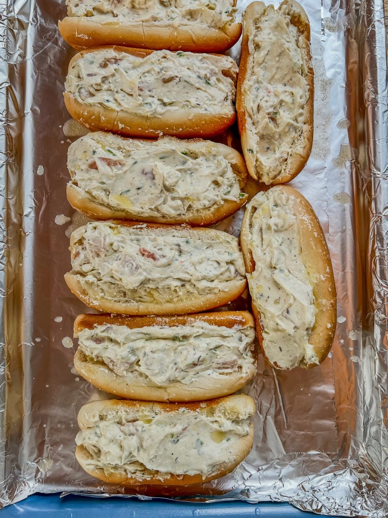 Buns stuffed with cream cheese and shrimp mixture on a baking sheet before being baked