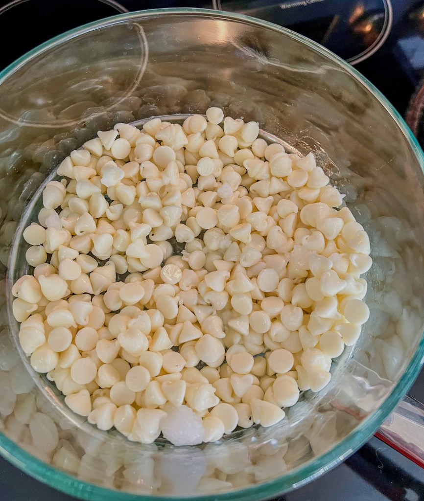 White chocolate chips melting in a pan on the stove