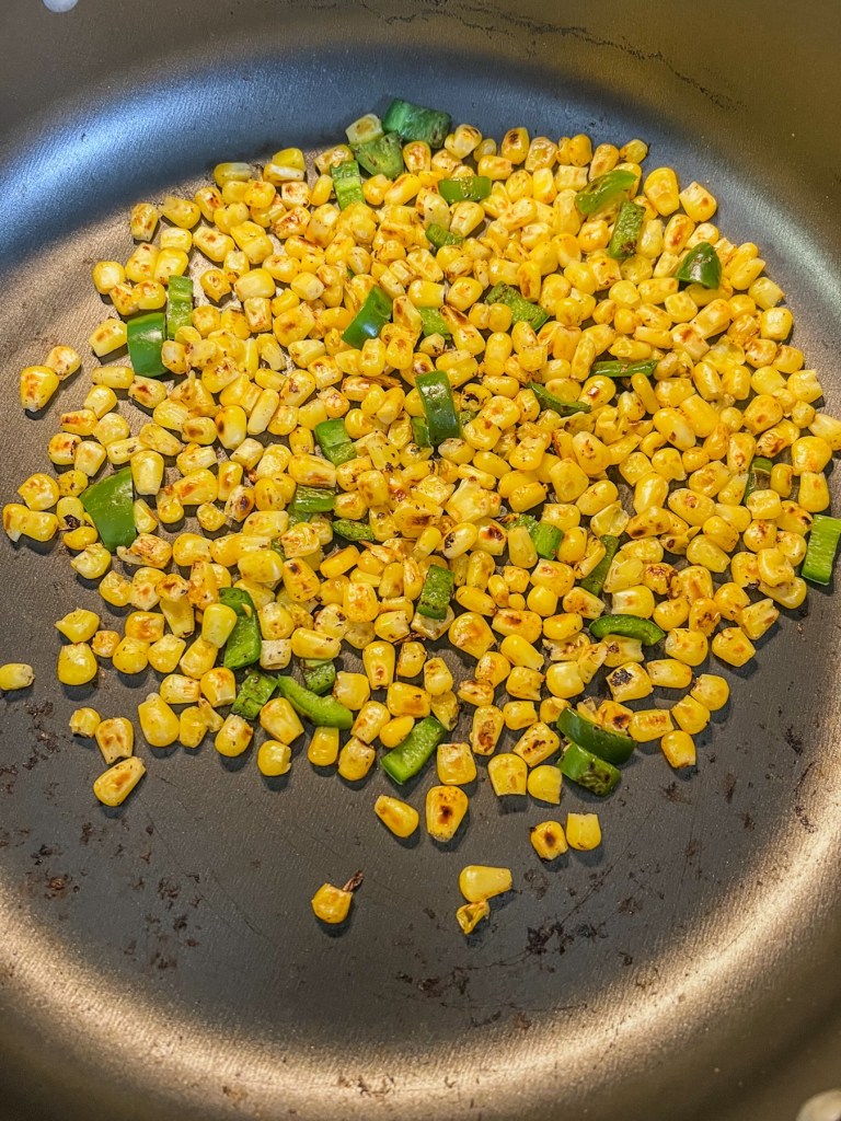 Corn and jalapeño cooking to a slight char in a skillet