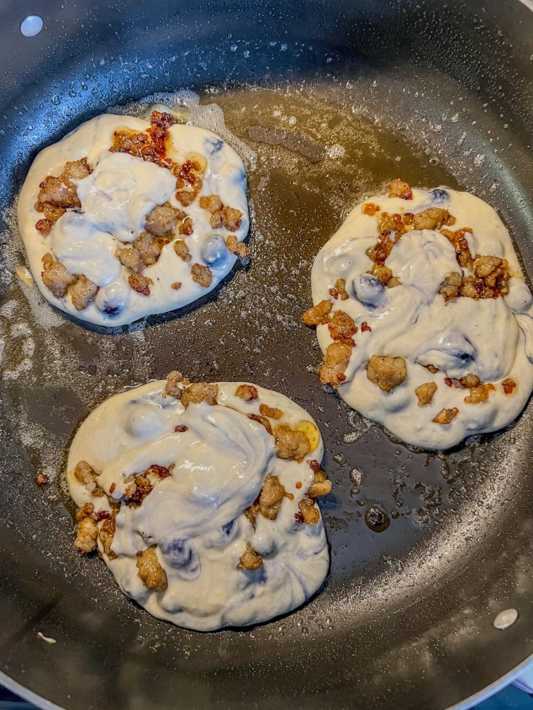 Stuffed pancakes cooking in a large skillet on the stove