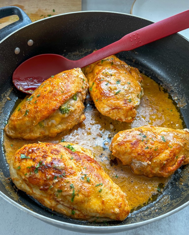 Broccoli cheddar stuffed chicken breasts in a pan with garlic Dijon sauce