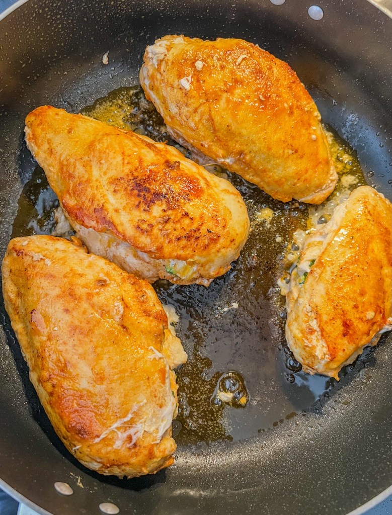 Chicken breasts cooking in a skillet