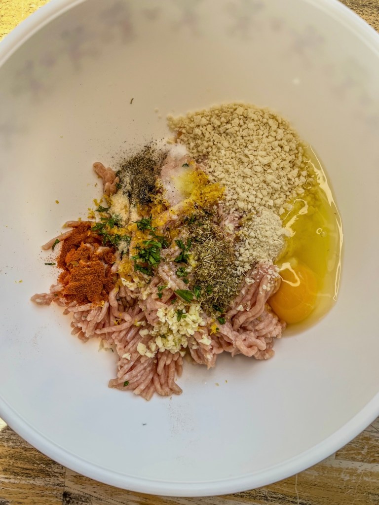 Ingredients for chicken burger patties in a mixing bowl