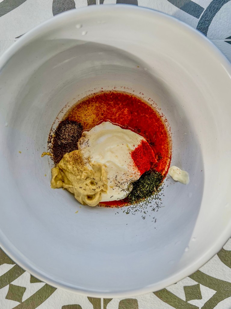 Dressing ingredients for creamy egg salad in a bowl before being mixed