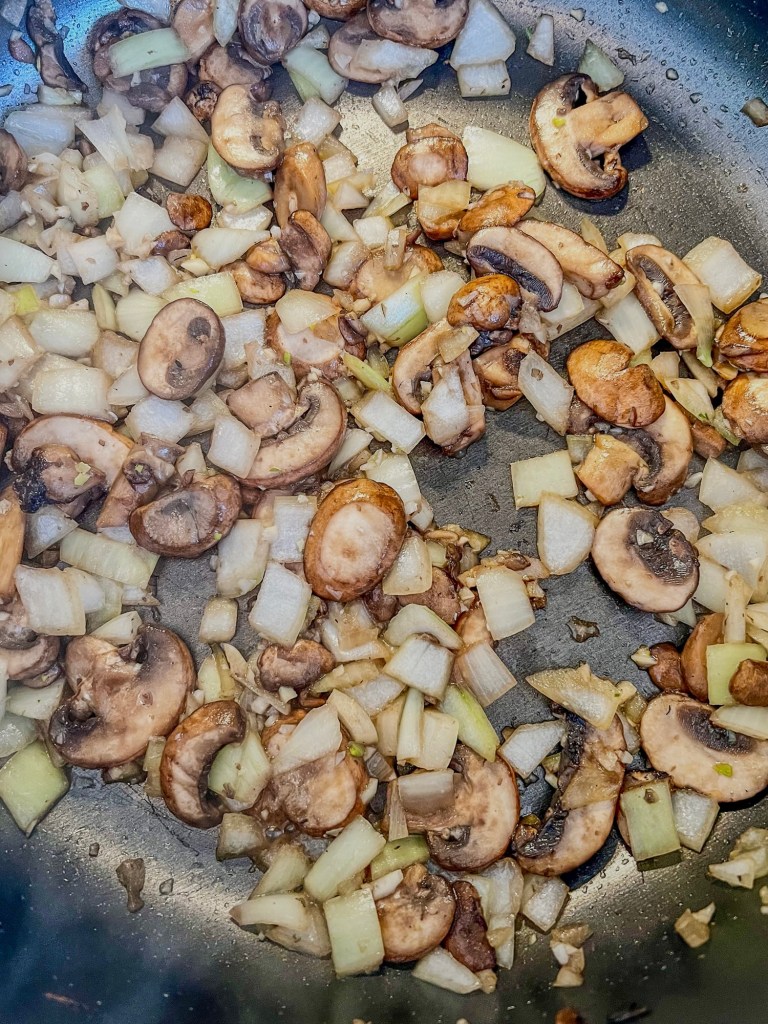 Mushrooms, onions, and garlic cooking in a skillet