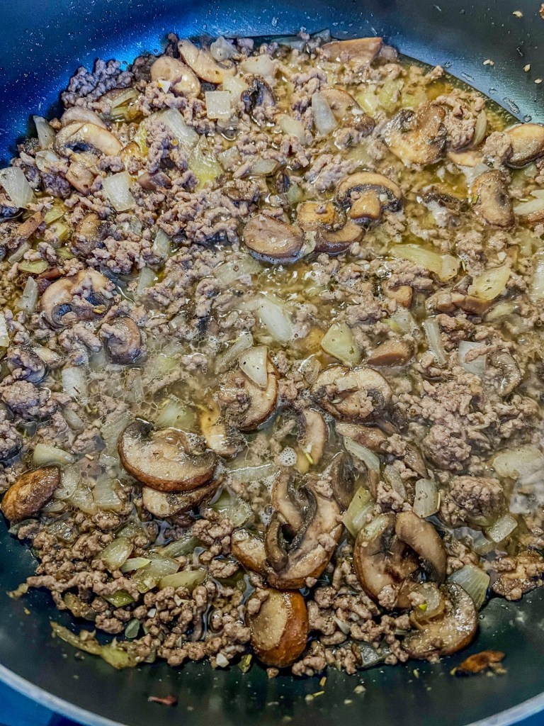 Filling for tater tot casserole cooking in a skillet