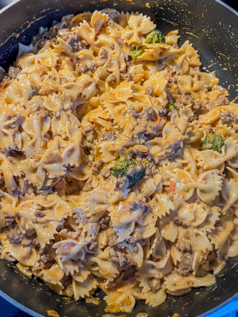 Creamy pasta with beef and broccoli in a skillet just before serving
