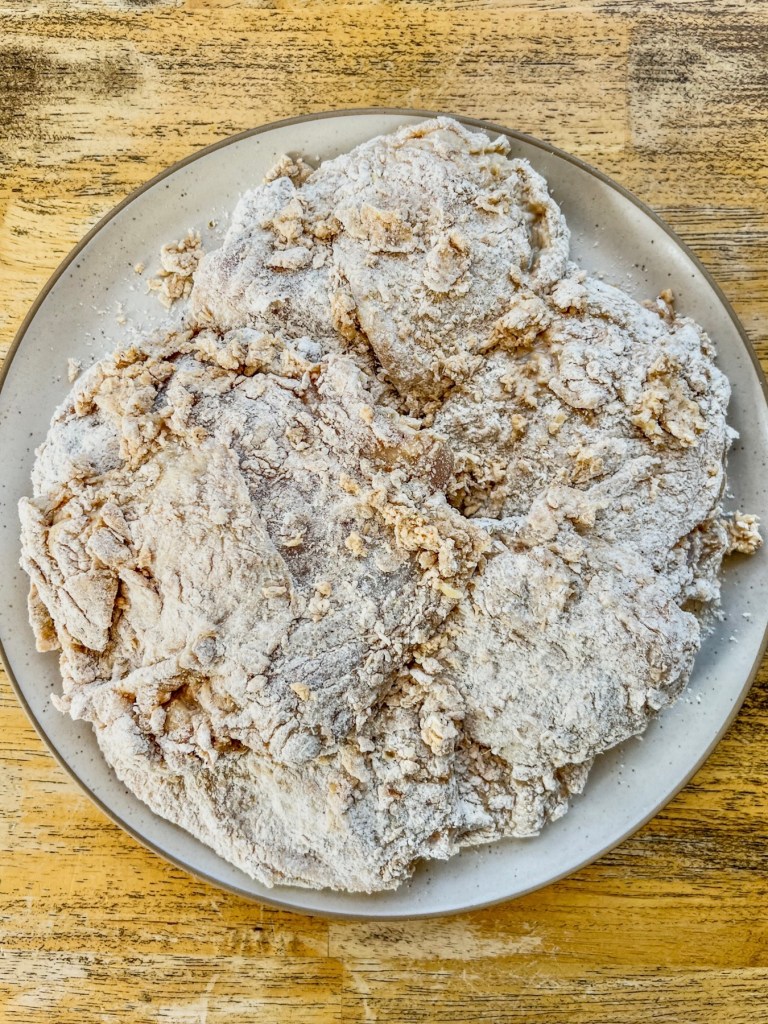 Chicken thighs that have been tossed in a flour mixture and buttermilk