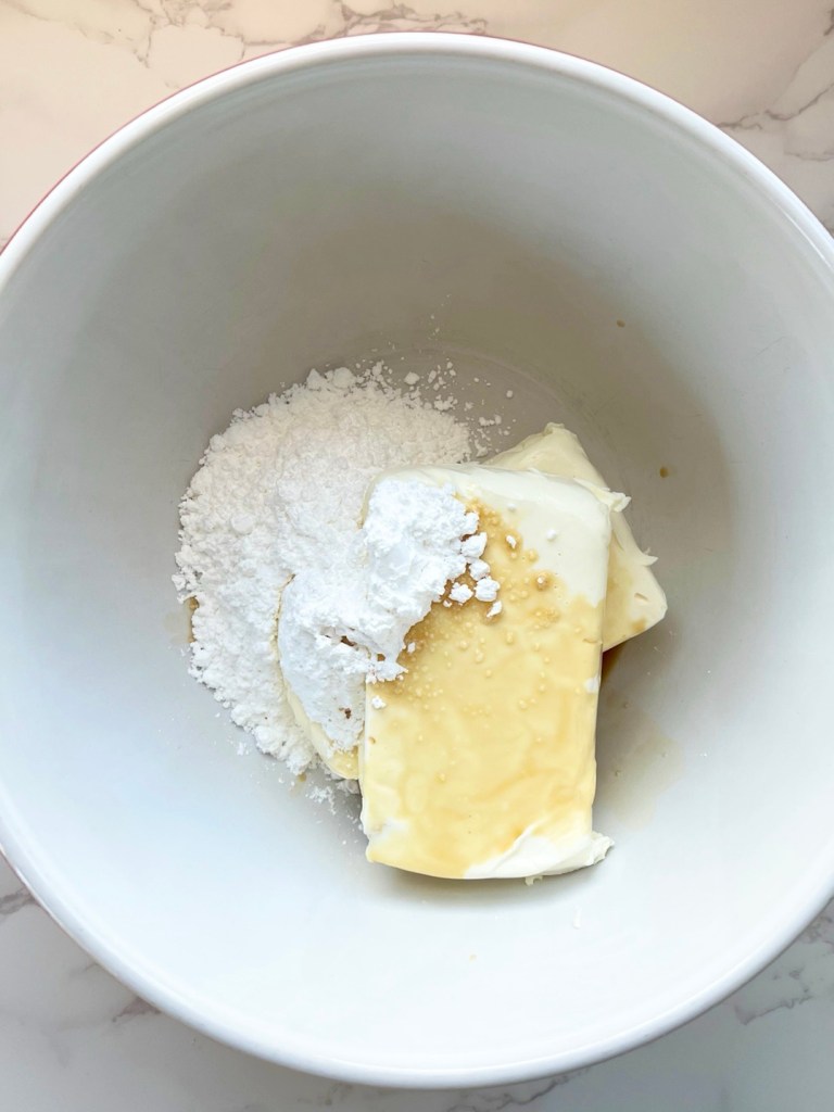 Cream cheese, vanilla, and powdered sugar in a mixing bowl