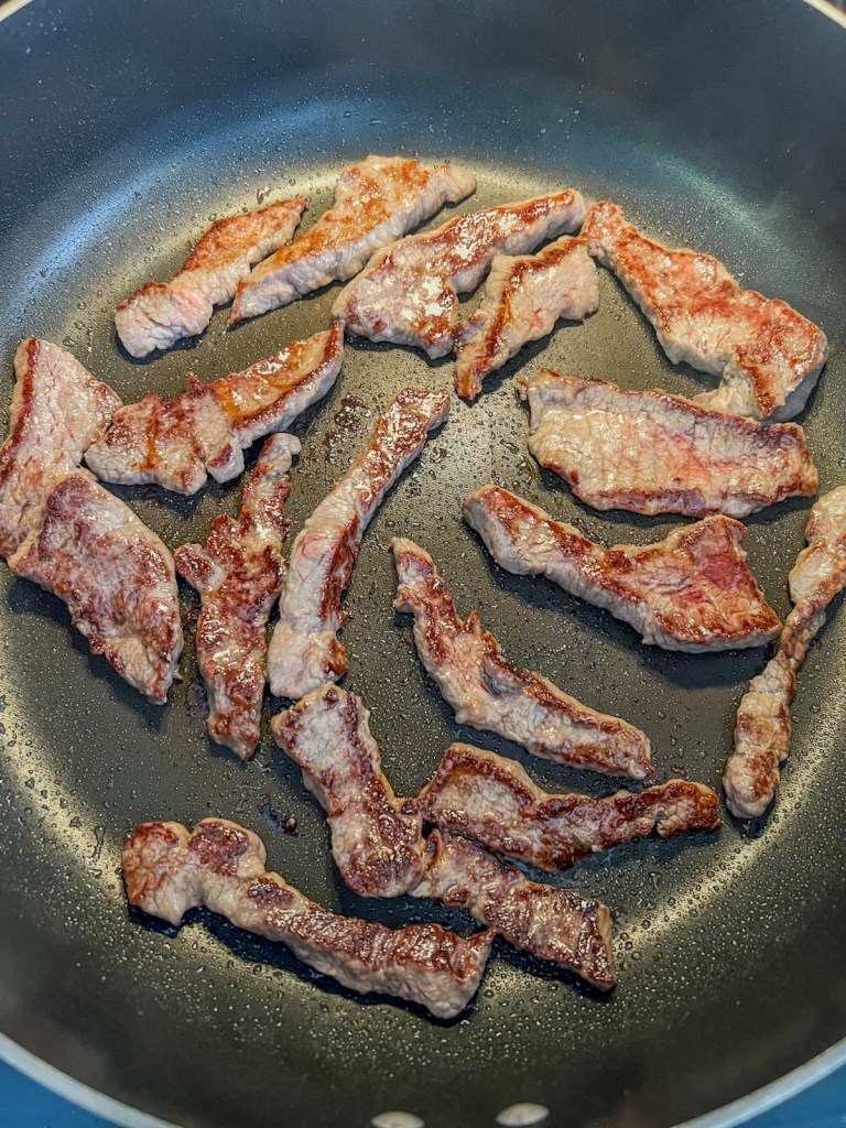 Stir fry beef cooking in a skillet