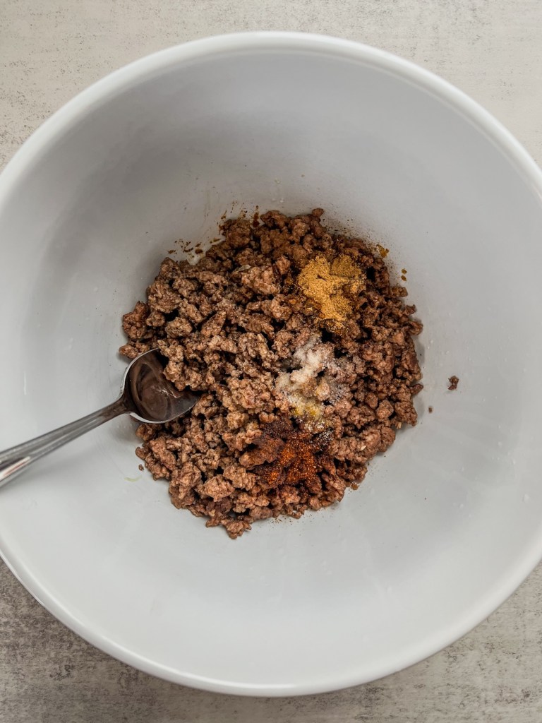 A large bowl filled with crispy ground beef, lime juice, and spices to make taco dip
