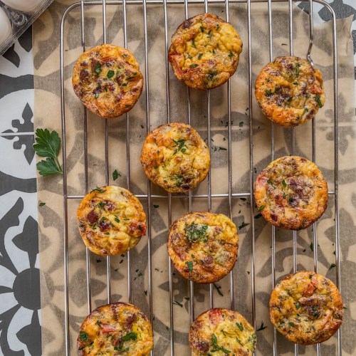 Broccoli cheddar egg cups on a cooling rack with fresh parsley on top