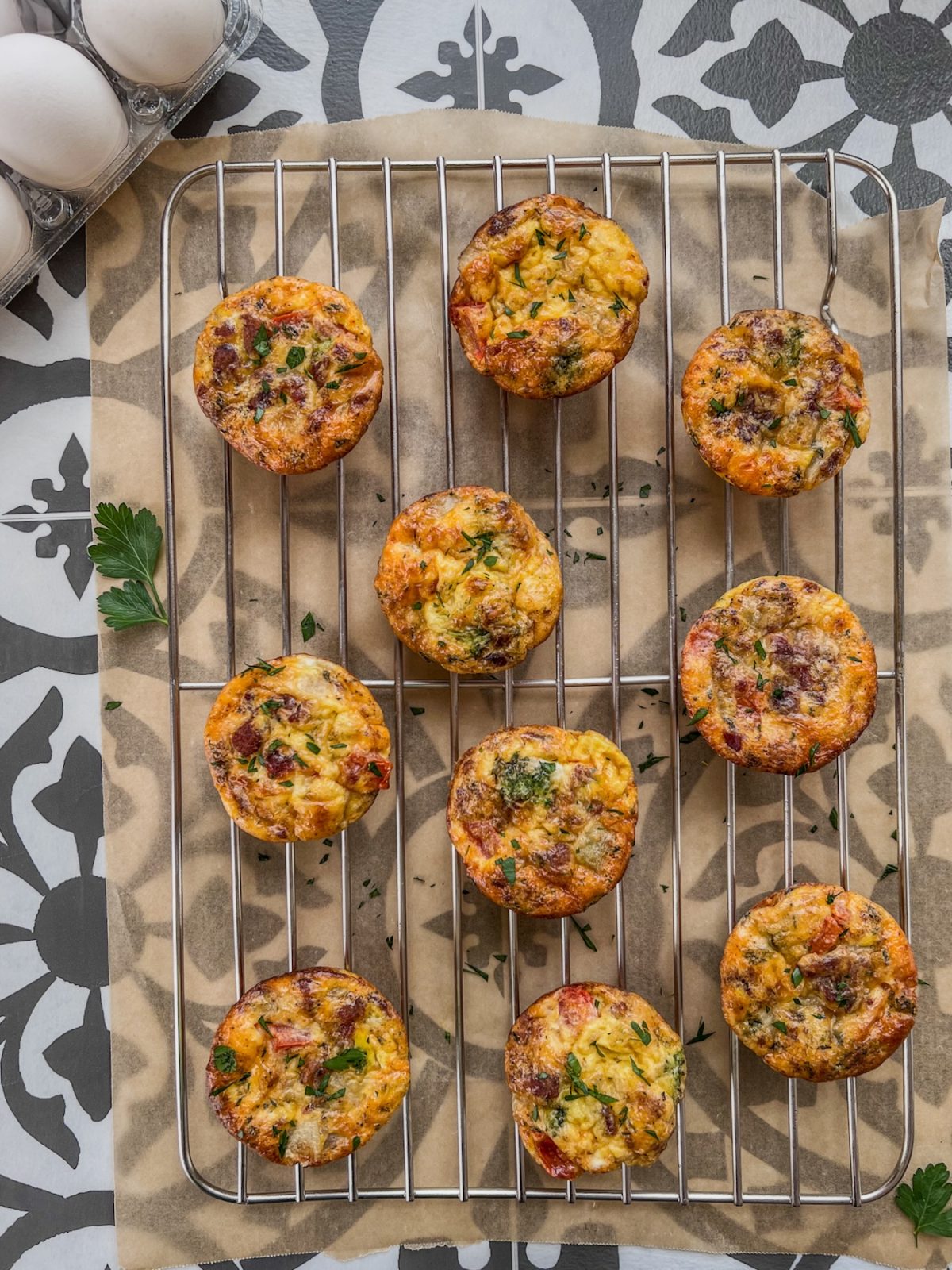 Broccoli cheddar egg cups on a cooling rack with fresh parsley on top