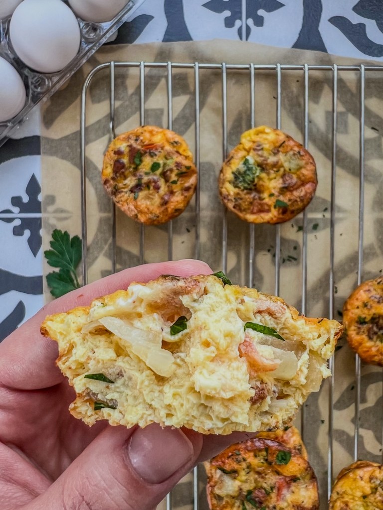 Broccoli cheddar egg cups with parsley for garnish served warm and fresh for breakfast