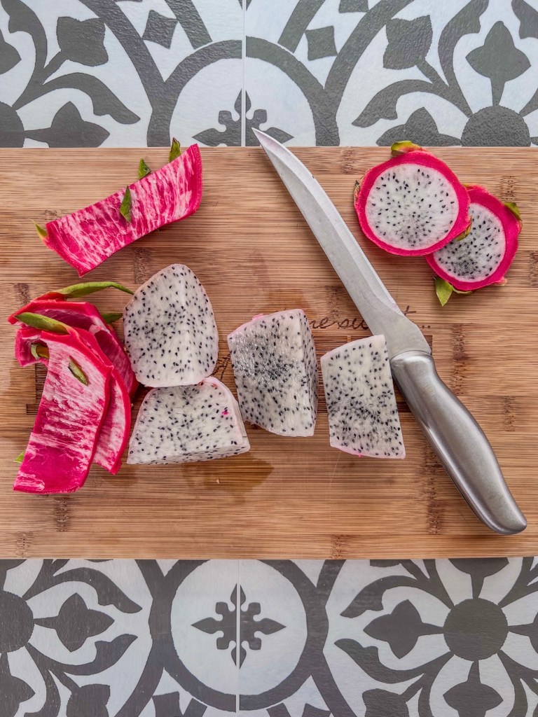 Dragon fruit peeled and cut into thirds on a cutting board
