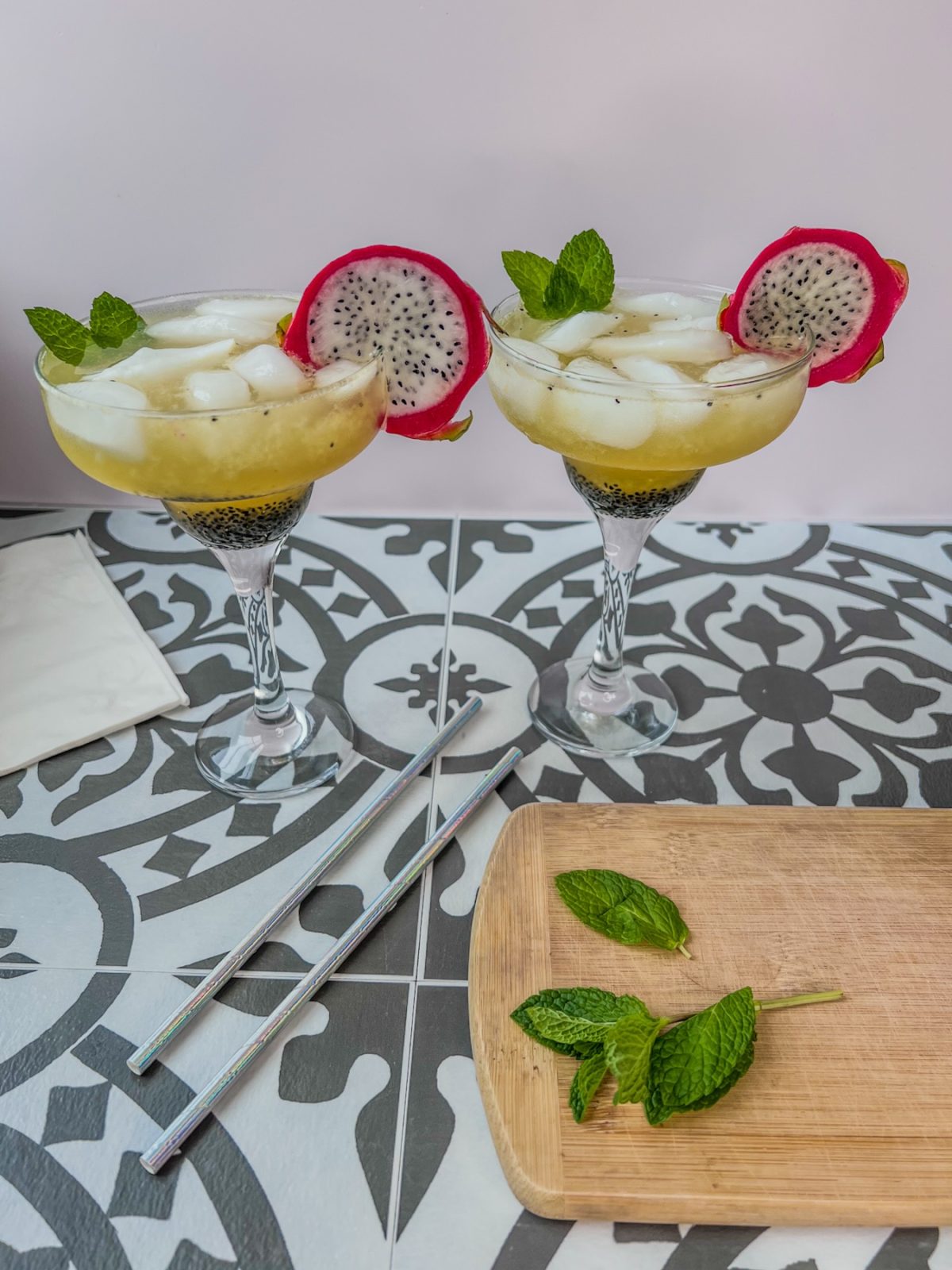 Dragon fruit rum cooler cocktails in some specialty glasses with mint and dragon fruit slices for garnish