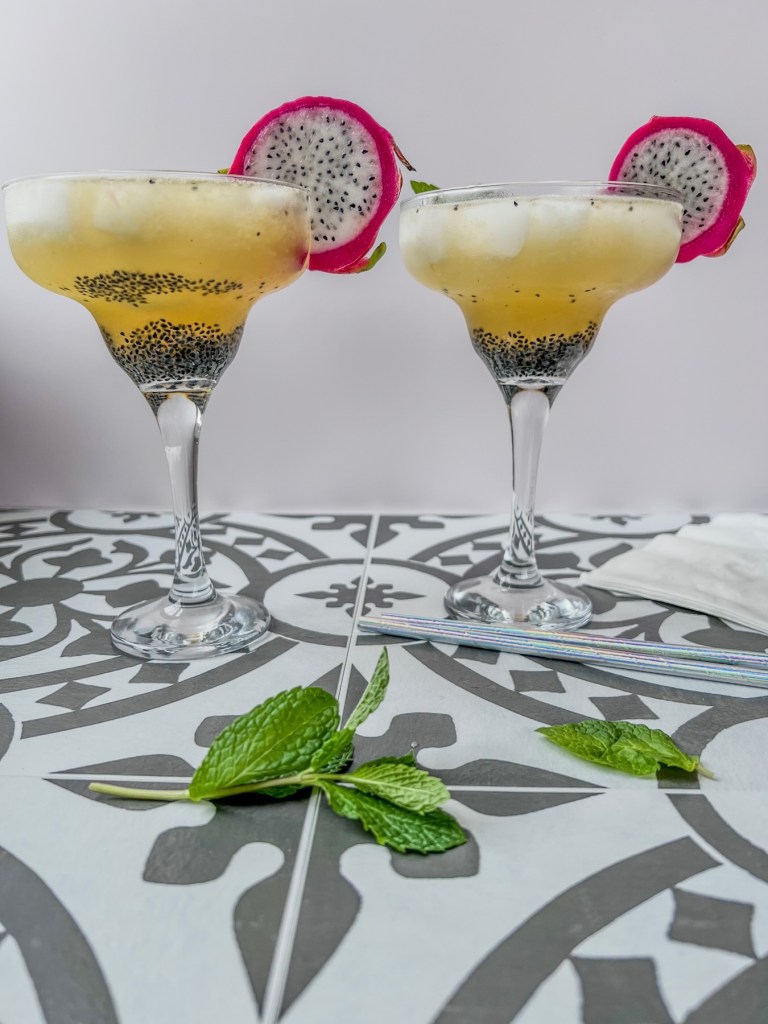 Dragon fruit rum cooler cocktails in glasses with mint and dragon fruit slices for garnish