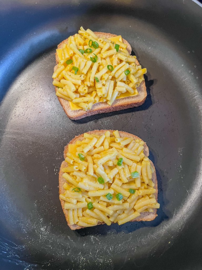 Mac and grilled cheese sandwiches frying in a large skillet