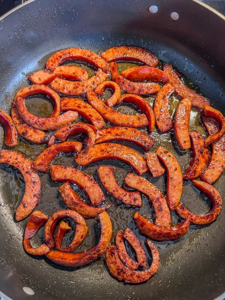 Smoked andouille sausage that's been cut into strips and seared in a skillet
