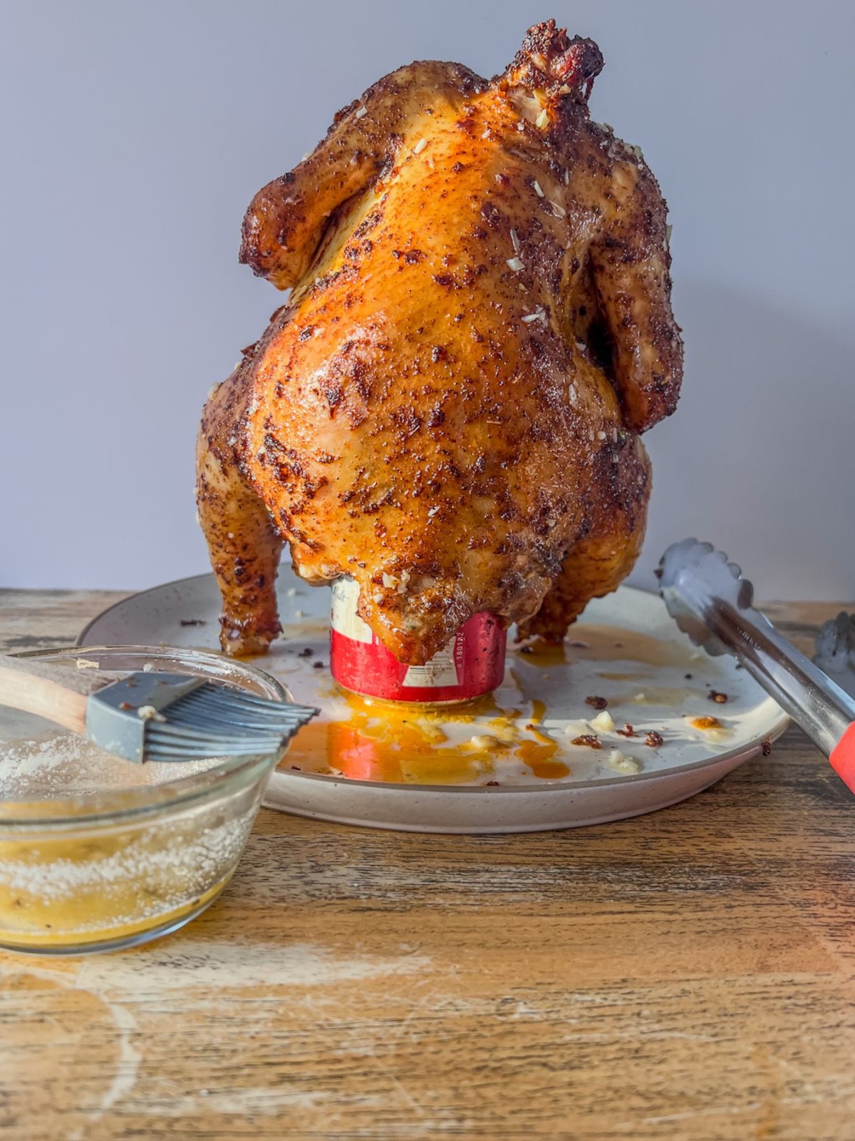 Smoked beer can chicken that's been brushed with garlic butter