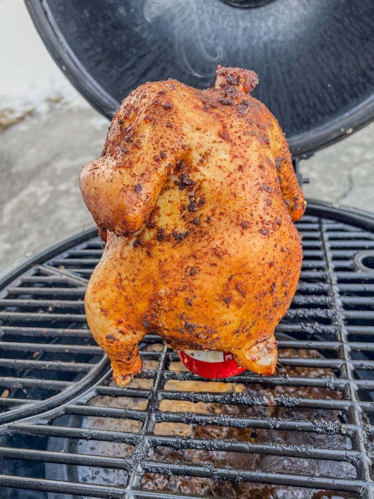 Smoked beer can chicken that's just finished cooking on the grill