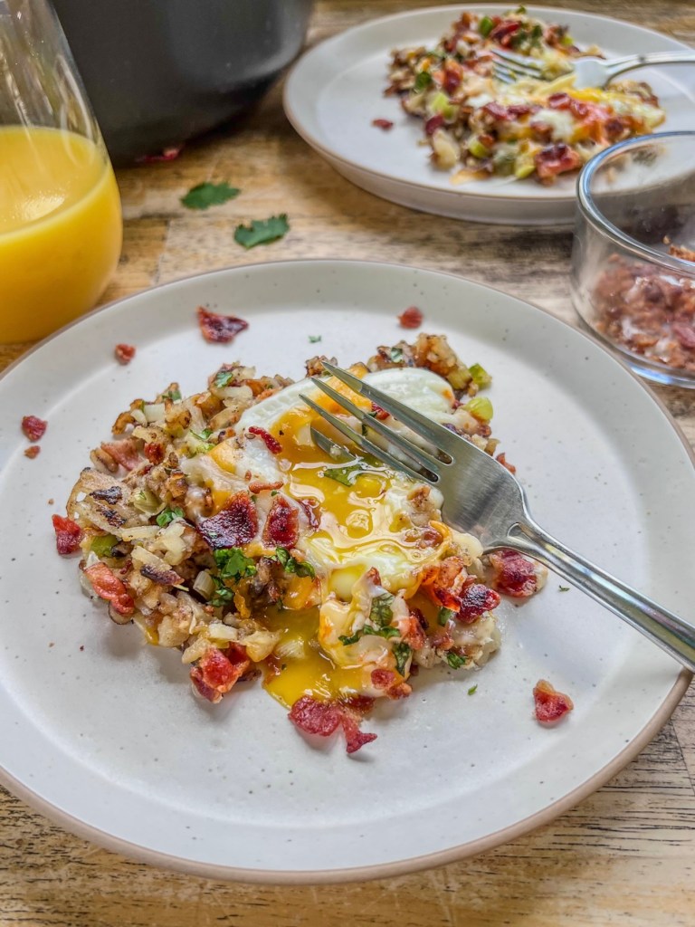 Bacon breakfast skillet served with bacon, cilantro, and hot sauce on top