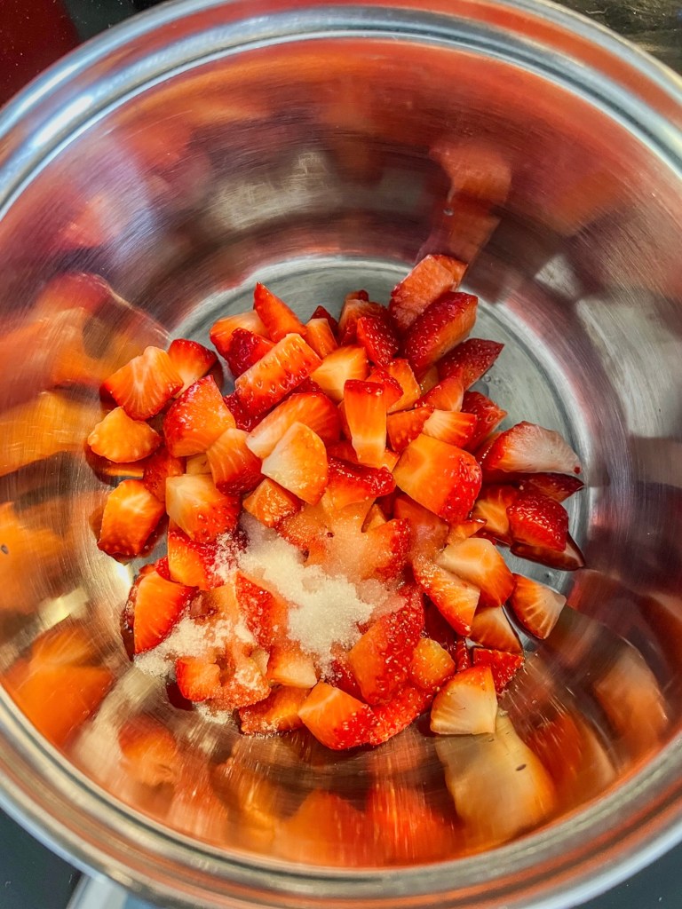 Ingredients for strawberry swirl popsicle layer in a small saucepan on the stove