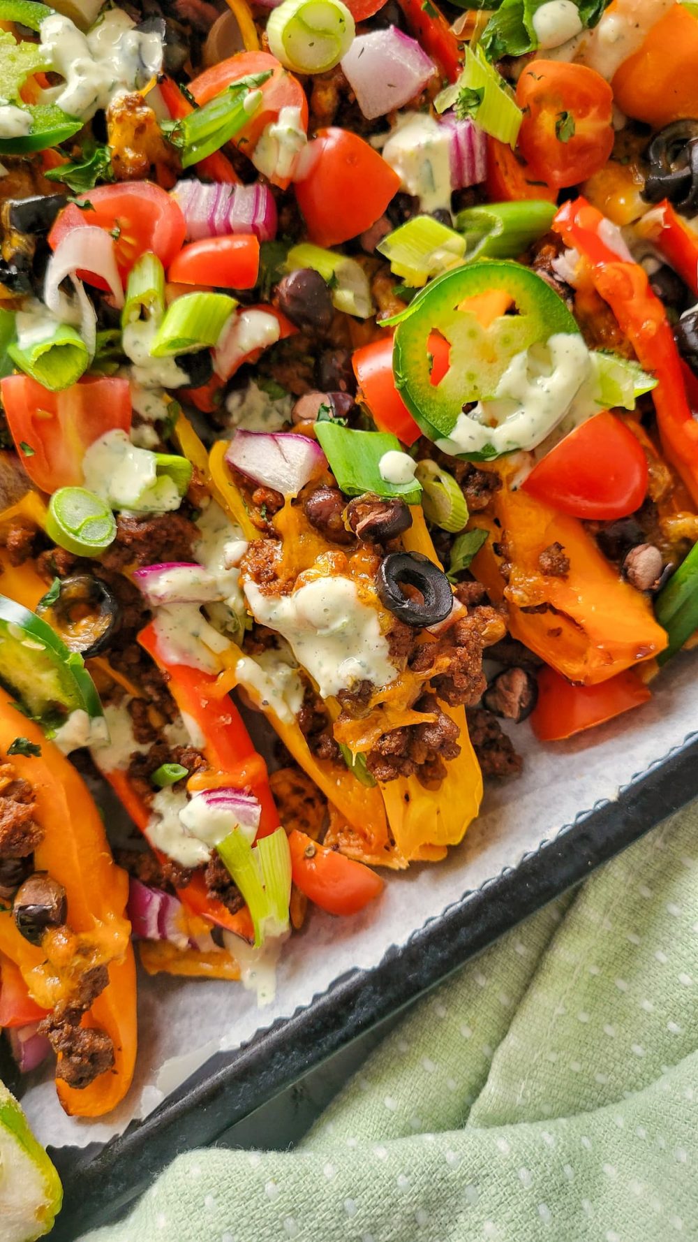 Bell pepper nachos on a serving platter with fresh garnishes scattered on top
