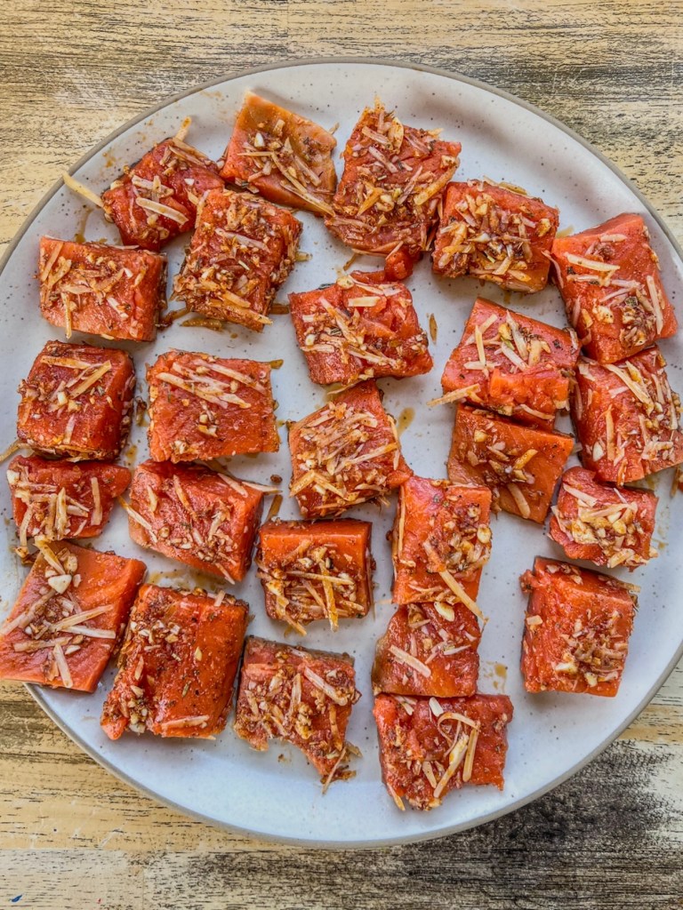 Salmon bites prepped on a plate before getting air fried