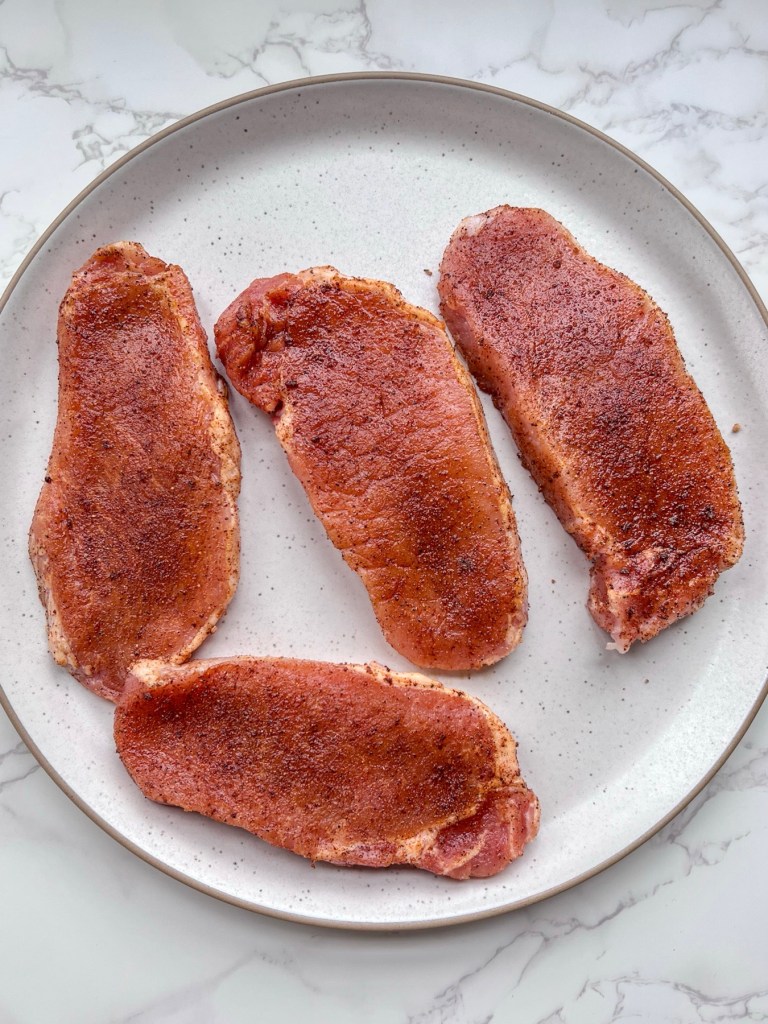 Thin cut pork chops that have been rubbed with espresso powder and a variety of spices