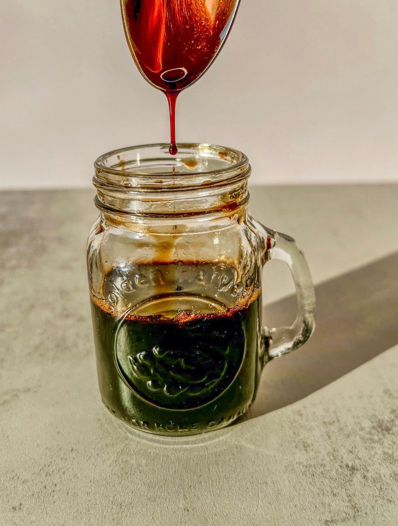 Homemade balsamic glaze coating the back of a spoon