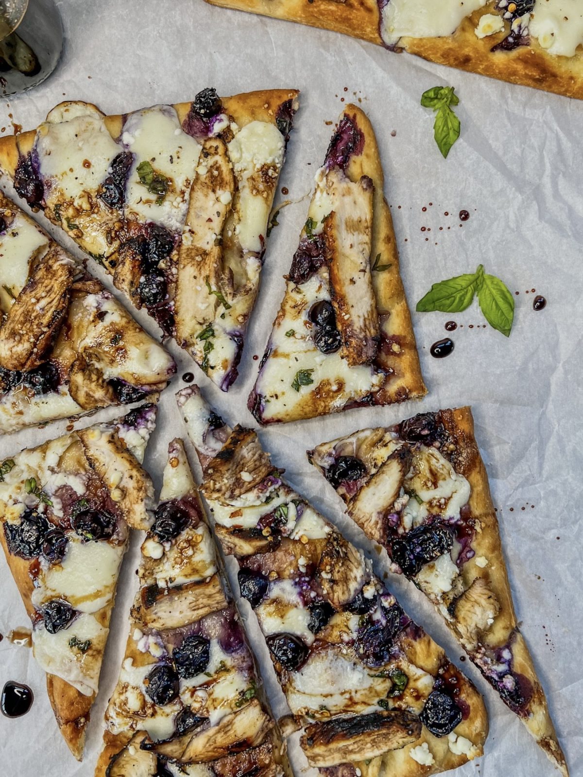Blueberry and goat cheese grilled chicken flatbreads fresh out of the oven with basil and balsamic 