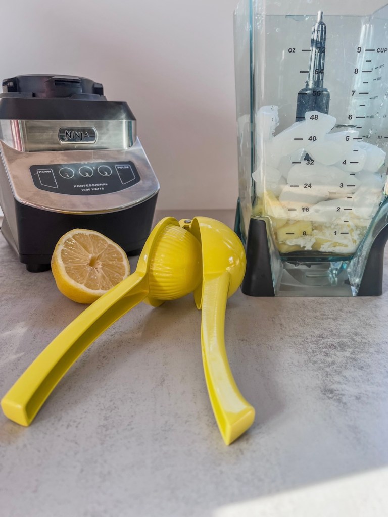 Frozen pineapple creamsicle colada ingredients in a blender before being blended up