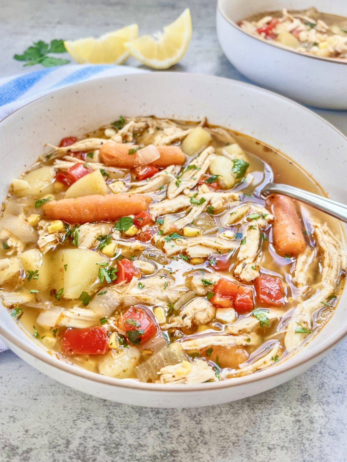 Garlic chicken immunity soup with some fresh lemon wedges off to the side