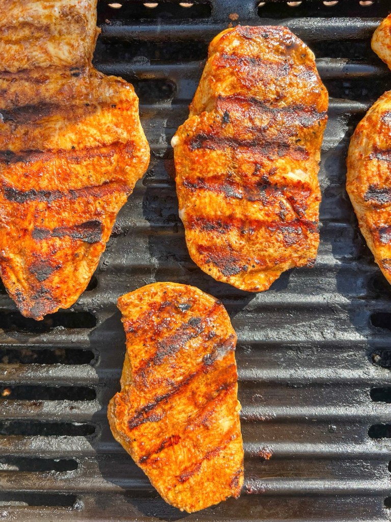 Marinated chicken breast cooking on the grill