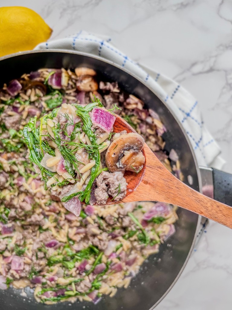 One pot creamy lemon orzo and beef with fresh dill and black pepper garnished on top