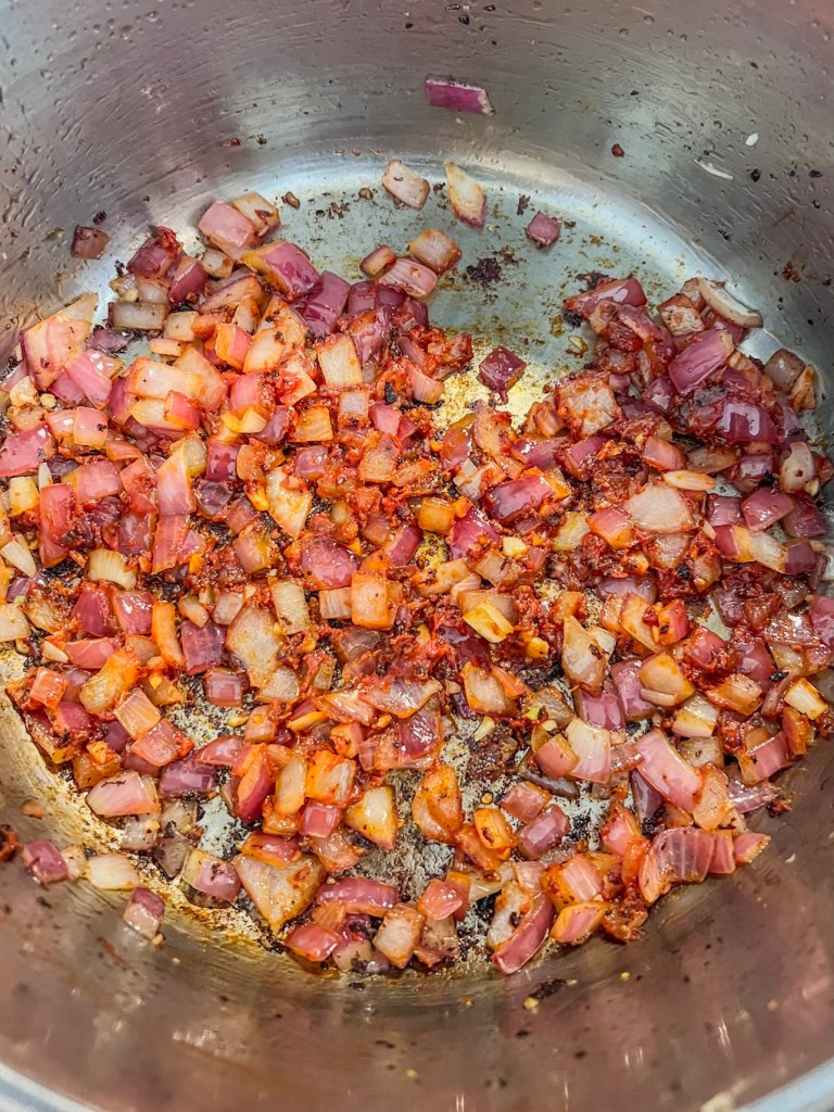 Onions, garlic, and tomato paste cooking in a stockpot