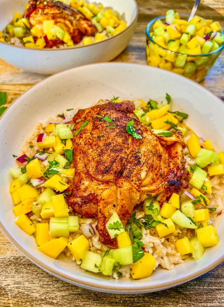 Tropical Chicken Thigh Bowls served with fresh cilantro on top and some mango salsa on the side