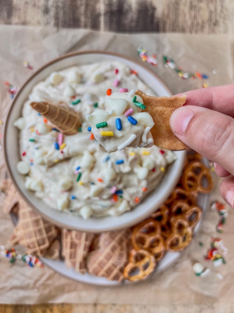 Cake batter cannoli dip served chilled with some shattered waffle cones and pretzels