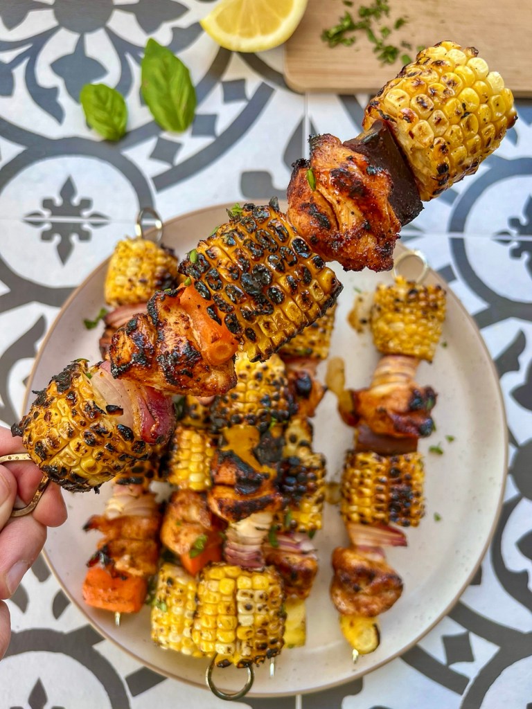 Hot honey chicken skewers with corn on the cob, lemon juice, and basil