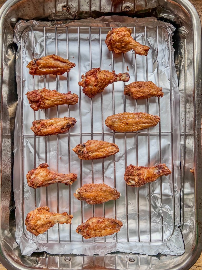Air fried chicken wings that are going into the oven to keep warm at 200°F.