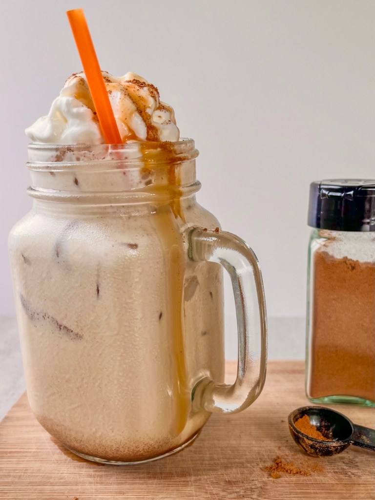 Iced pumpkin caramel espresso cream with whipped cream, caramel, and pumpkin pie spice on top.